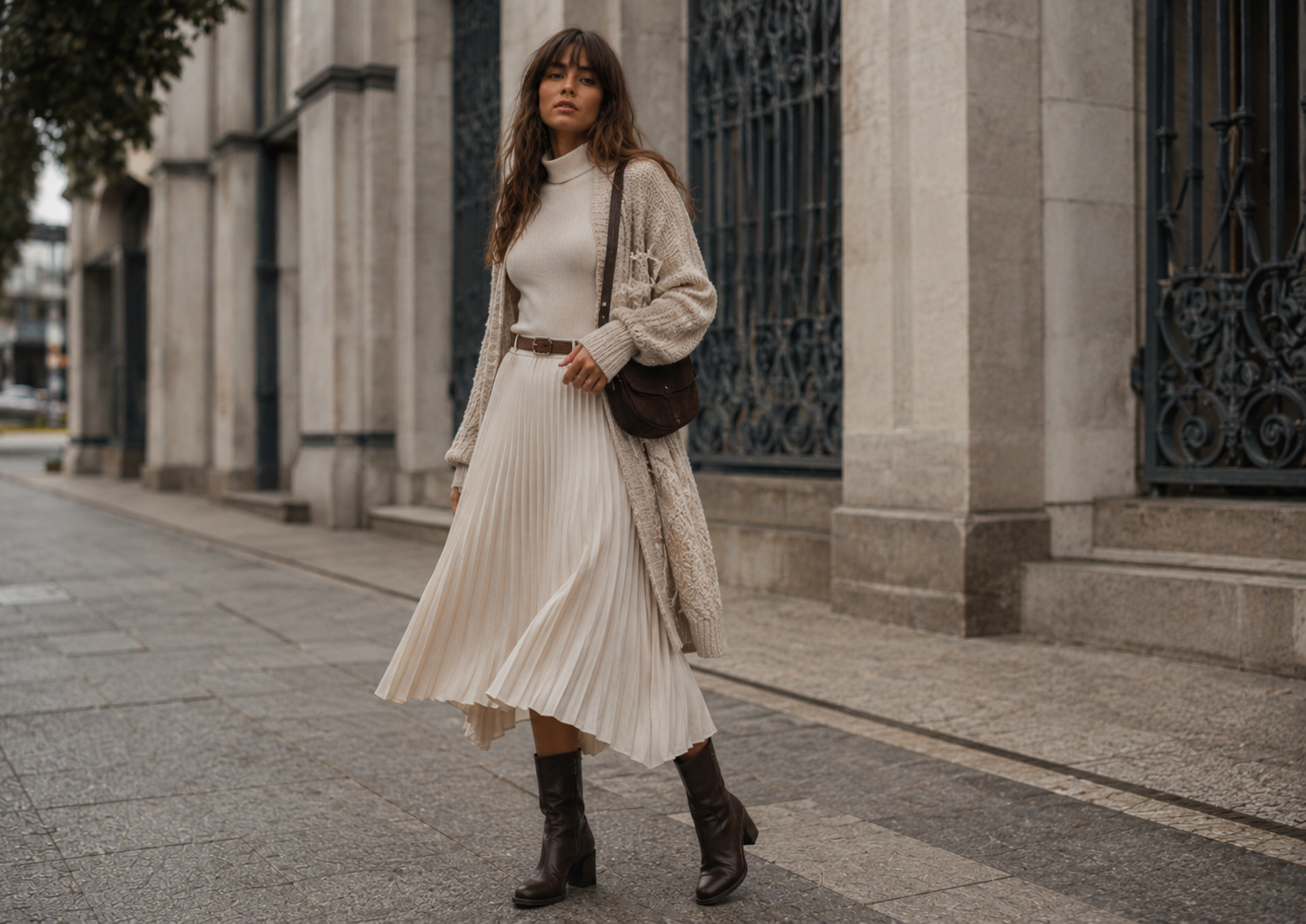 Saia plissada off-white, gola alta, cardigan e botas em proposta folk para inverno ameno.