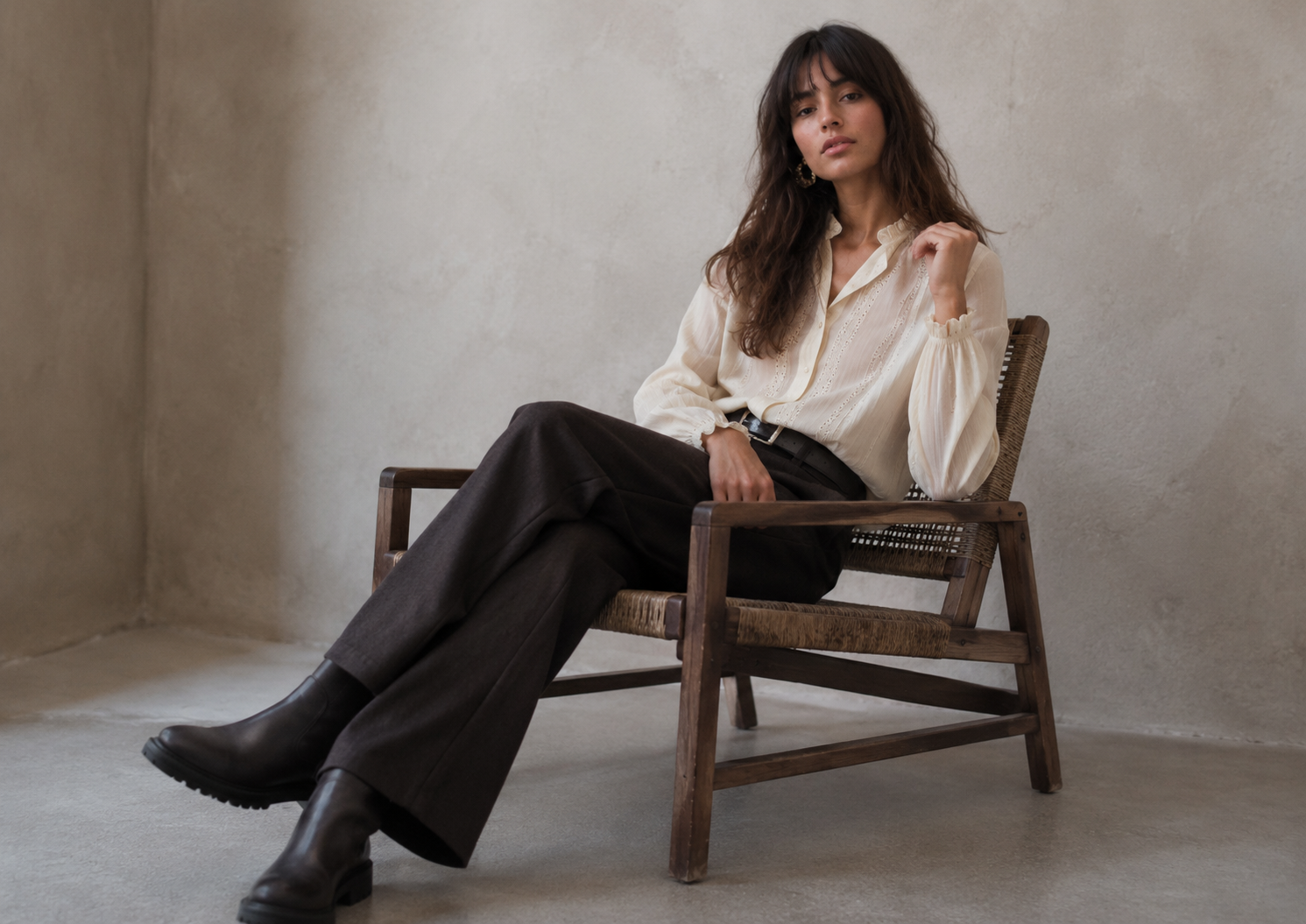 Blusa delicada com detalhe de renda, calça estruturada e botas em look folk romântico cotidiano.